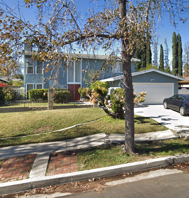 Image of blue two story home with black vehicle in the driveway